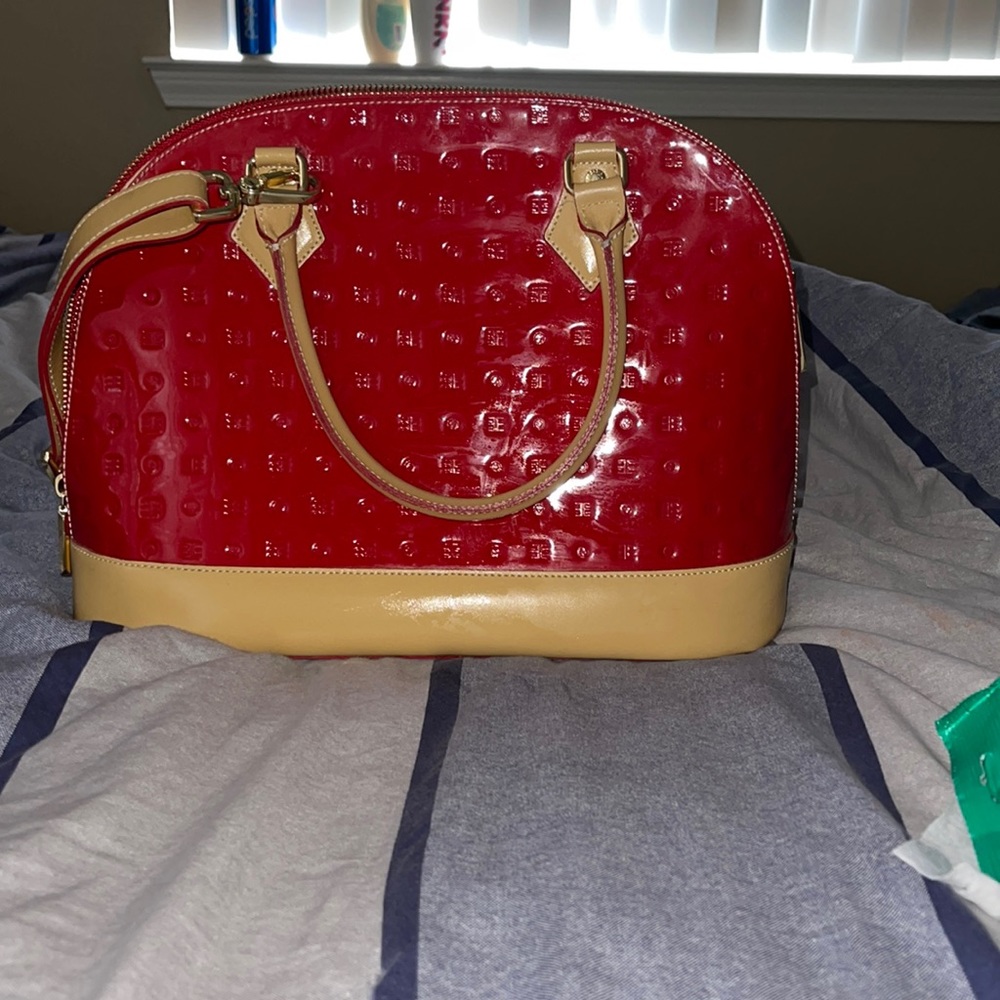 Very shiny Ruby red purse. With strap. In great condition